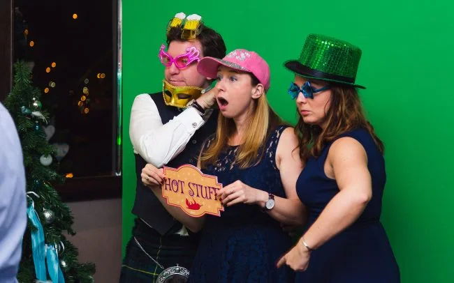 3 people standing in front of green screen having a picture taken